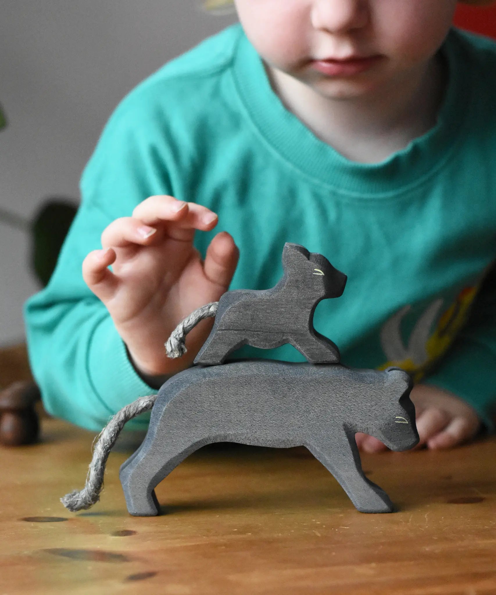 Ostheimer small running panther wooden toy figure placed on the back of a large one. 