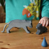 Child playing with the Ostheimer black panther handmade wooden toy figures.
