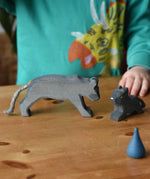 Child playing with the Ostheimer black panther handmade wooden toy figures.