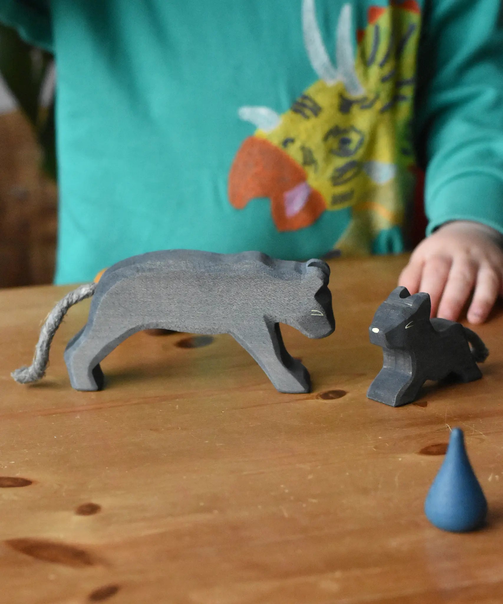 Child playing with the Ostheimer black panther handmade wooden toy figures.