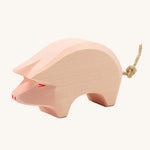 Ostheimer Pig toy figure with it's head held down low on a plain background. 