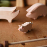 A close up of the Ostheimer piglet placed on a wooden surface.  These wooden figures are part of a wide range of expertly hand crafted wooden toys here at Babipur. 