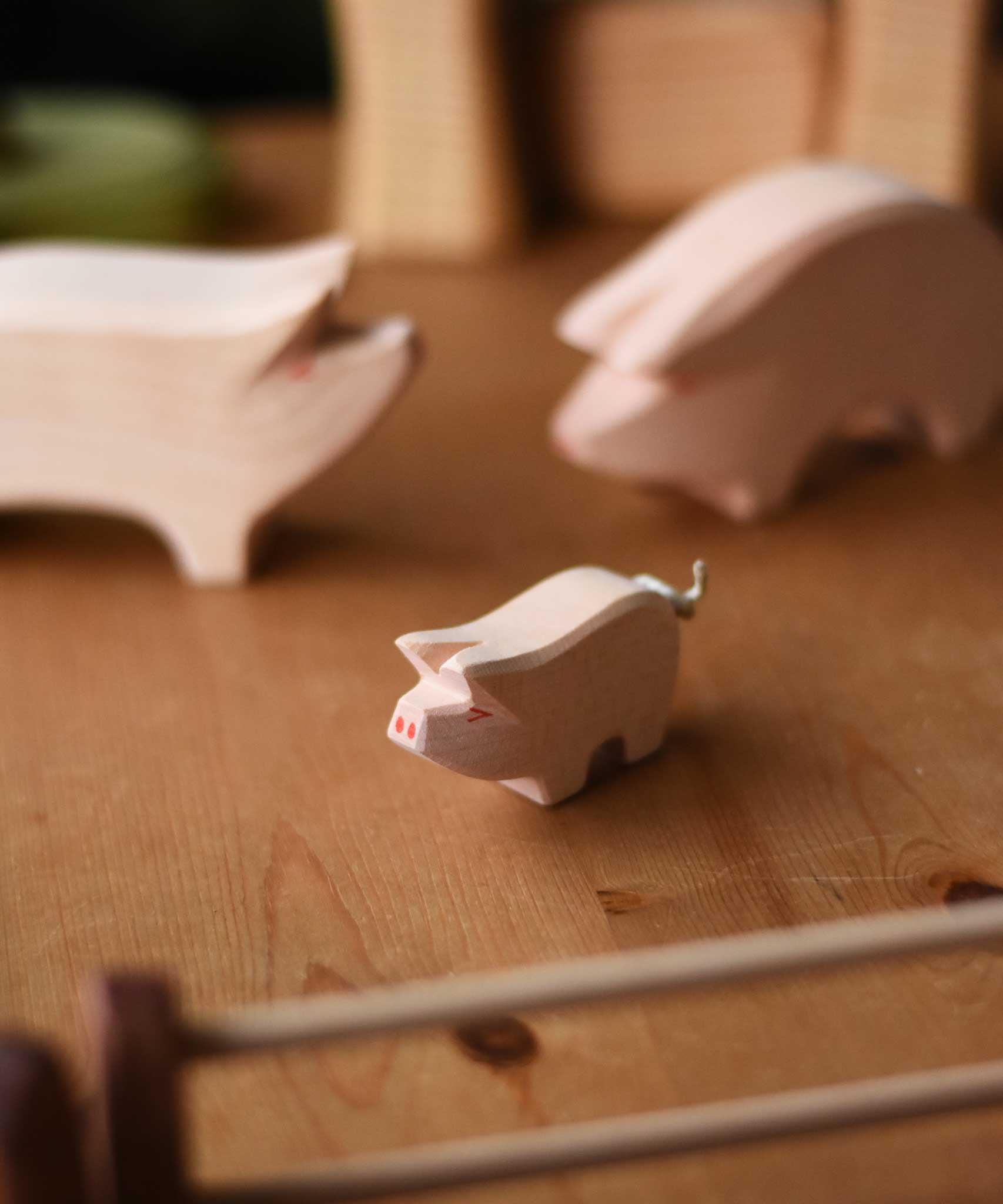 A close up of the Ostheimer piglet placed on a wooden surface.  These wooden figures are part of a wide range of expertly hand crafted wooden toys here at Babipur. 