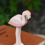 A close up of an Ostheimer flamingo placed on a pile of books.