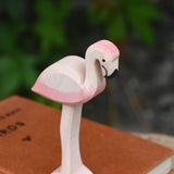 A close up of an Ostheimer flamingo placed on a pile of books.