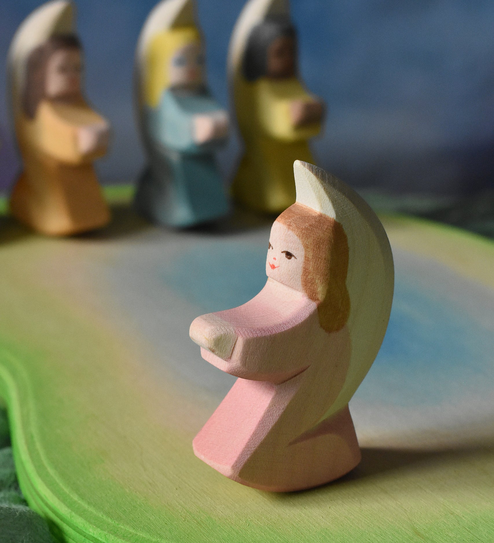A pink coloured Ostheimer little angel placed on an Ostheimer pond piece in a small world play set up. This wooden figure is part of a large range of expertly hand crafted, Waldorf inspired, wooden toys here at Babipur. 