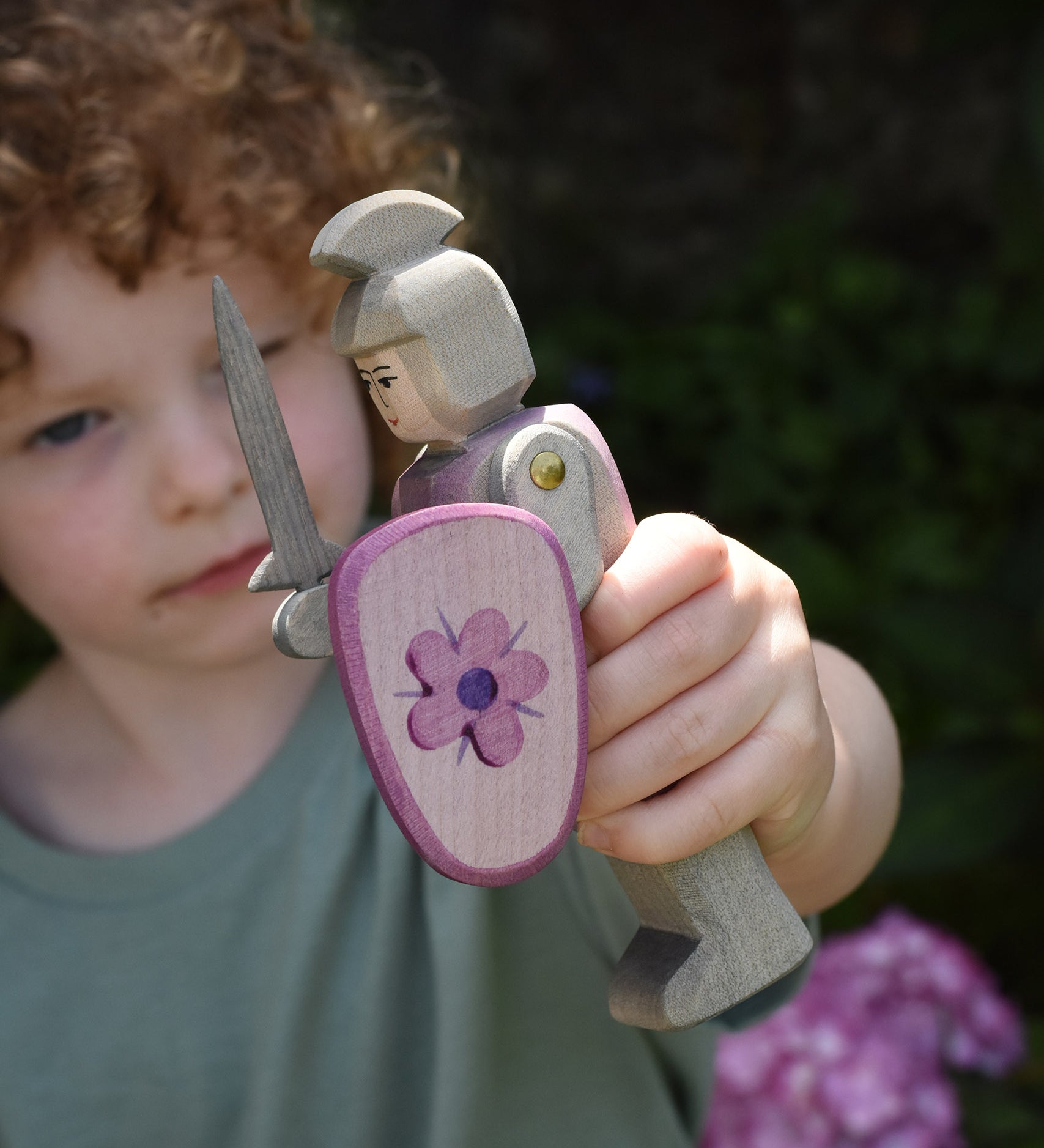 A child holding an Ostheimer pink standing knight in his hand. This wooden figure is part of a large range of expertly hand crafted wooden toys here at Babipur. 