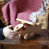 Child twirling the propellor on teh front of the Ostheimer Natural Open Plane With 1 red Person doll placed inside.