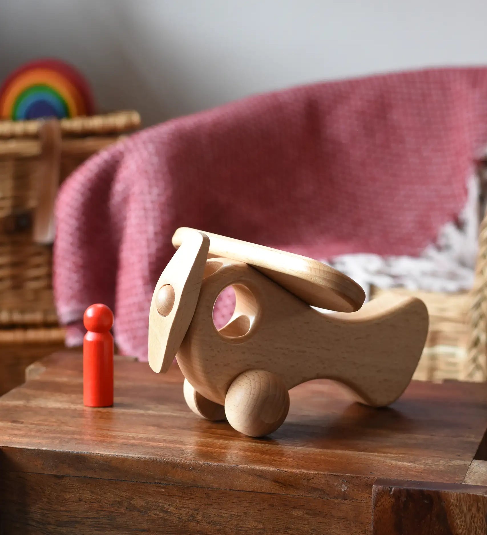 Ostheimer Natural Open Plane With 1 red Person doll placed on a wooden stool.
