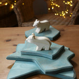 Ostheimer polar bear wooden toy figure with a long neck placed on a stack of ice floe scenery pieces. 