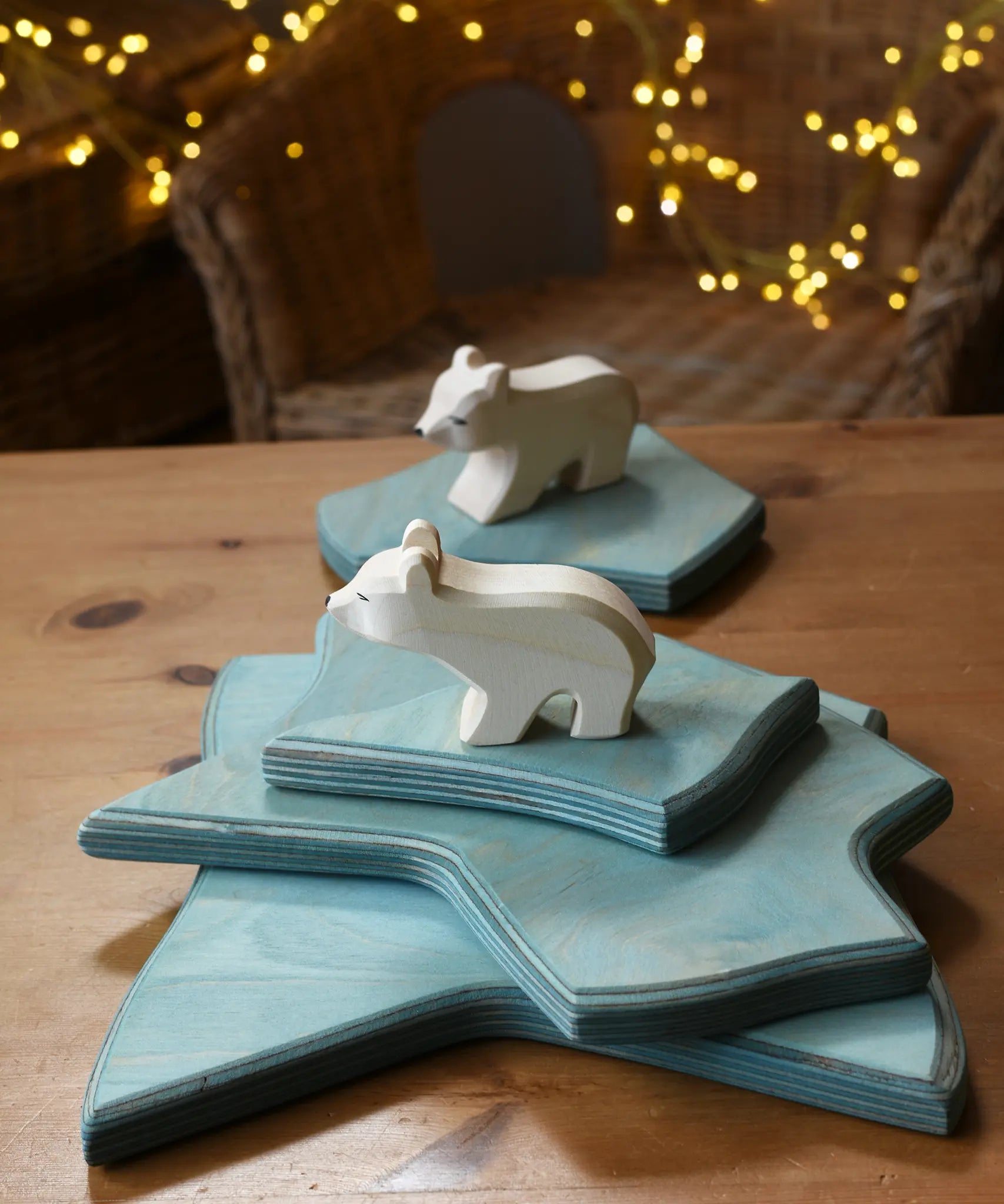 Ostheimer polar bear wooden toy figure with a long neck placed on a stack of ice floe scenery pieces. 