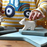 Ostheimer polar bear wooden toy figure with a short neck placed on a stack of ice floe scenery pieces. 