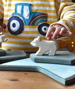 Ostheimer polar bear wooden toy figure with a short neck placed on a stack of ice floe scenery pieces. 