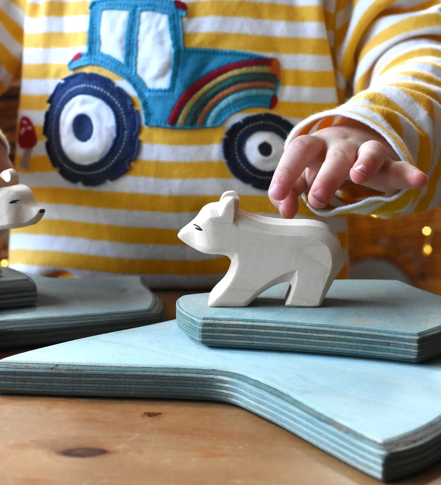 Ostheimer polar bear wooden toy figure with a short neck placed on a stack of ice floe scenery pieces. 
