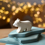 Ostheimer polar bear wooden toy figure with a short neck placed on a stack of ice floe scenery pieces. 