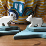Ostheimer polar bear wooden toy figures placed on a stack of ice floe scenery pieces. 