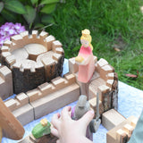 An Ostheimer pink princess for frog prince wooden toy figure placed on a turret of the Magic Wood castle. This wooden figure is part of a large range of expertly hand crafted, Waldorf inspired, wooden toys here at Babipur. 