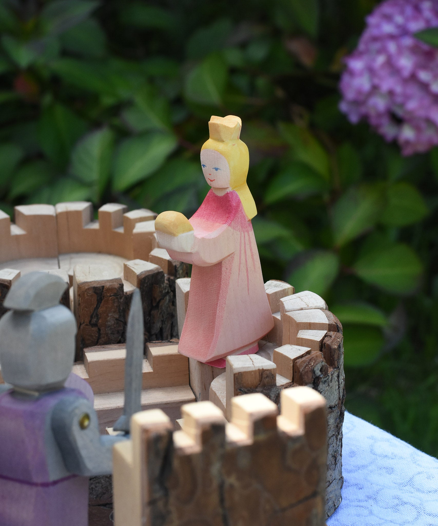 An Ostheimer pink princess for frog prince placed on the turret of a Magic Wood castle. This wooden figure is part of a large range of expertly hand crafted, Waldorf inspired, wooden toys here at Babipur. 