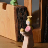 Ostheimer princess for frog king on a wooden surface in front of the tower and castle walls with the frog king in the background.