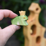 An Ostheimer wooden frog price wooden toy figure shown in an adult's finger's for scale. This wooden figure is part of a large range of expertly hand crafted wooden toys here at Babipur. 