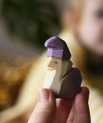 Ostheimer amethyst dwarf wooden toy figure in an adult's hand.