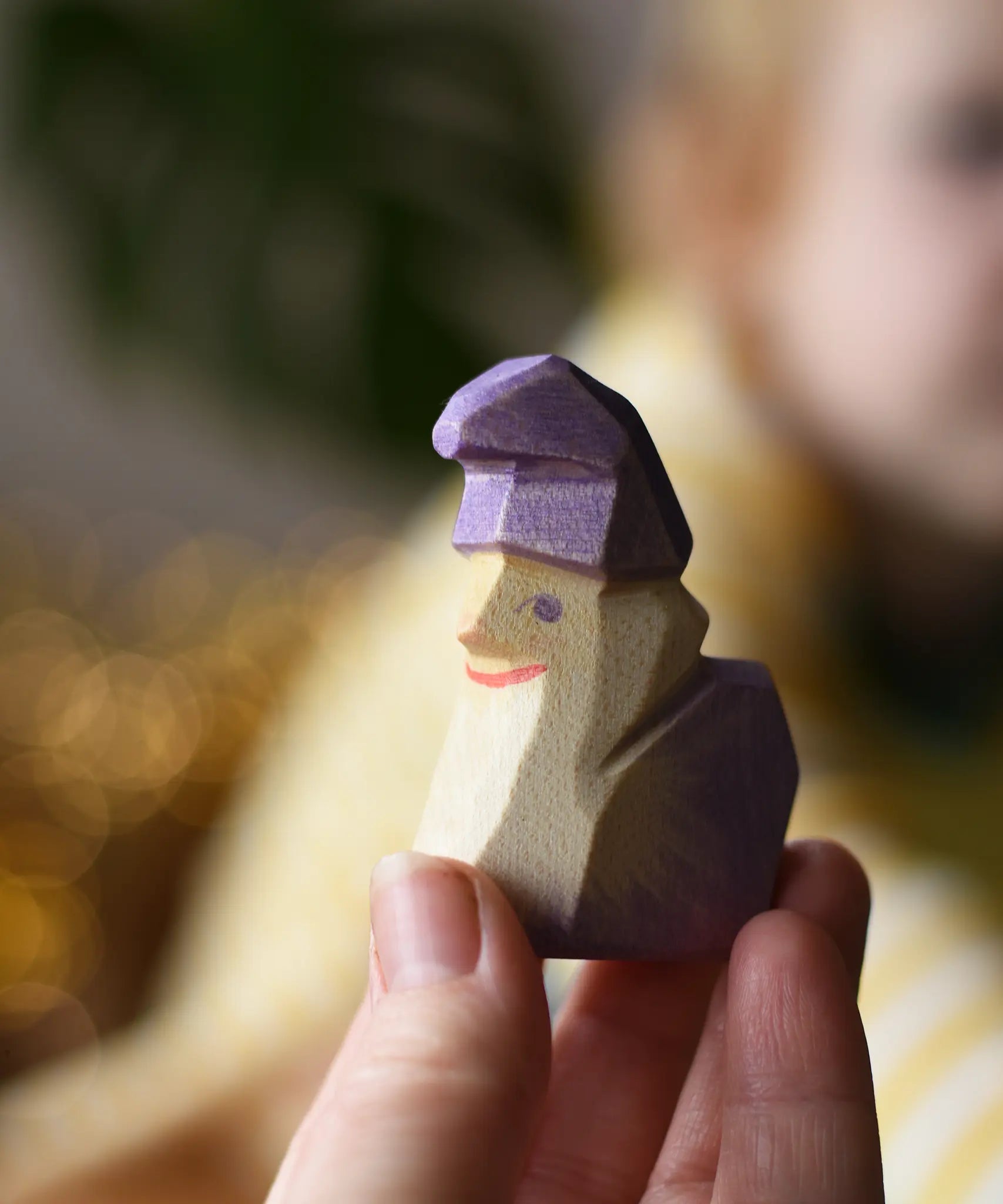 Ostheimer amethyst dwarf wooden toy figure in an adult's hand.