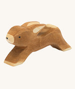 Ostheimer wooden toy running rabbit figure on a cream background. 