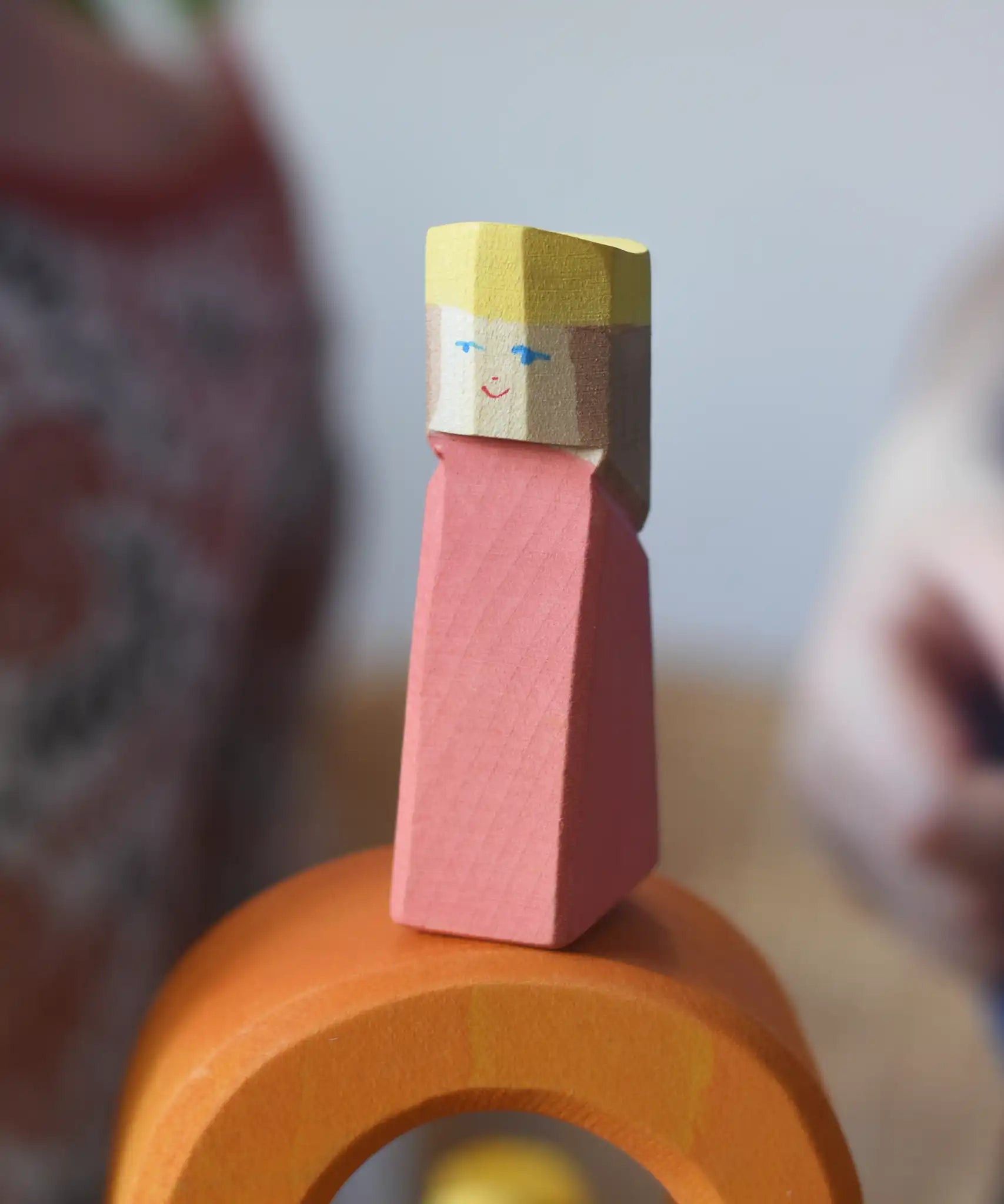 Red king wooden figures from the Ostheimer Rainbow Castle Block set placed on orange arch piece. 