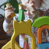 Ostheimer Rainbow Castle Blocks being played with by a child placing the king wooden figures on the yellow castle piece.