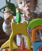 Ostheimer Rainbow Castle Blocks being played with by a child placing the king wooden figures on the yellow castle piece.
