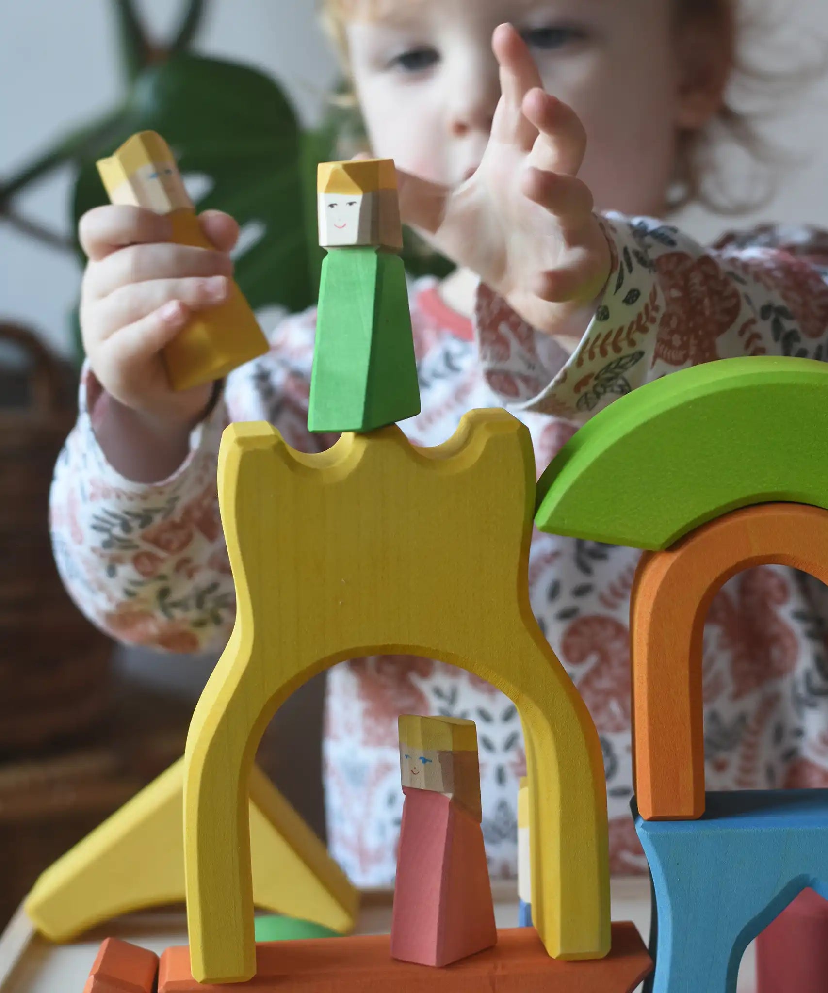 Ostheimer Rainbow Castle Blocks being played with by a child placing the king wooden figures on the yellow castle piece.