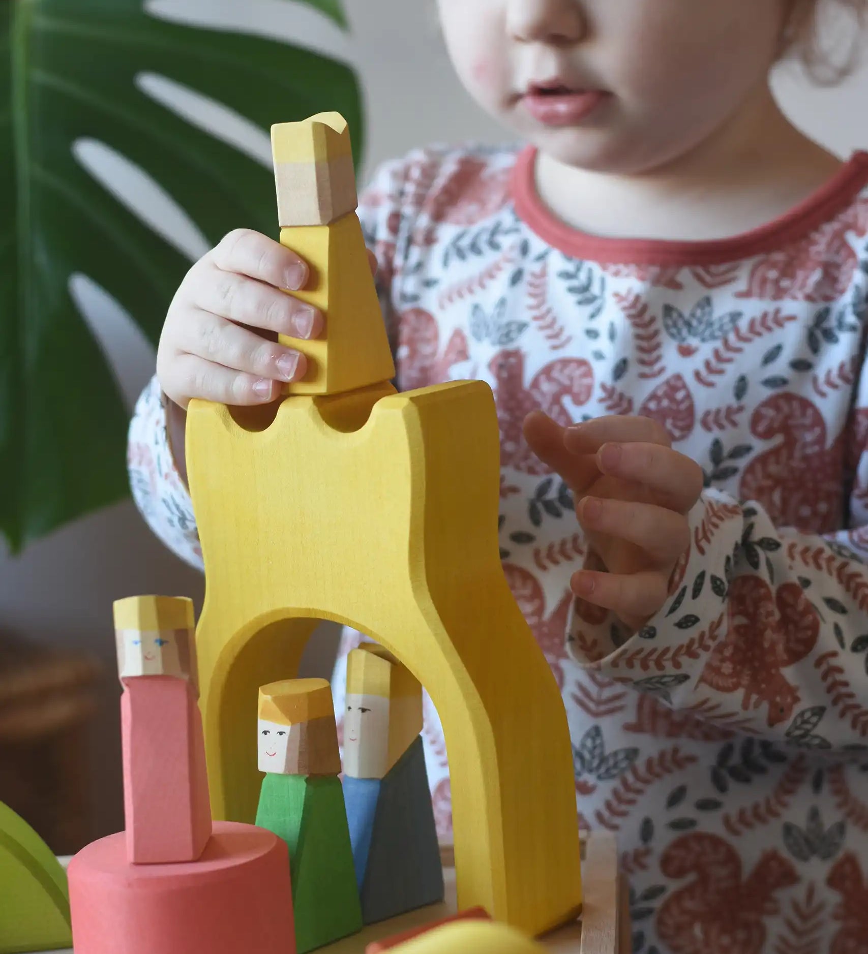 Yellow king wooden figure placed on the yellow castle piece from the Ostheimer Rainbow Castle Block set.