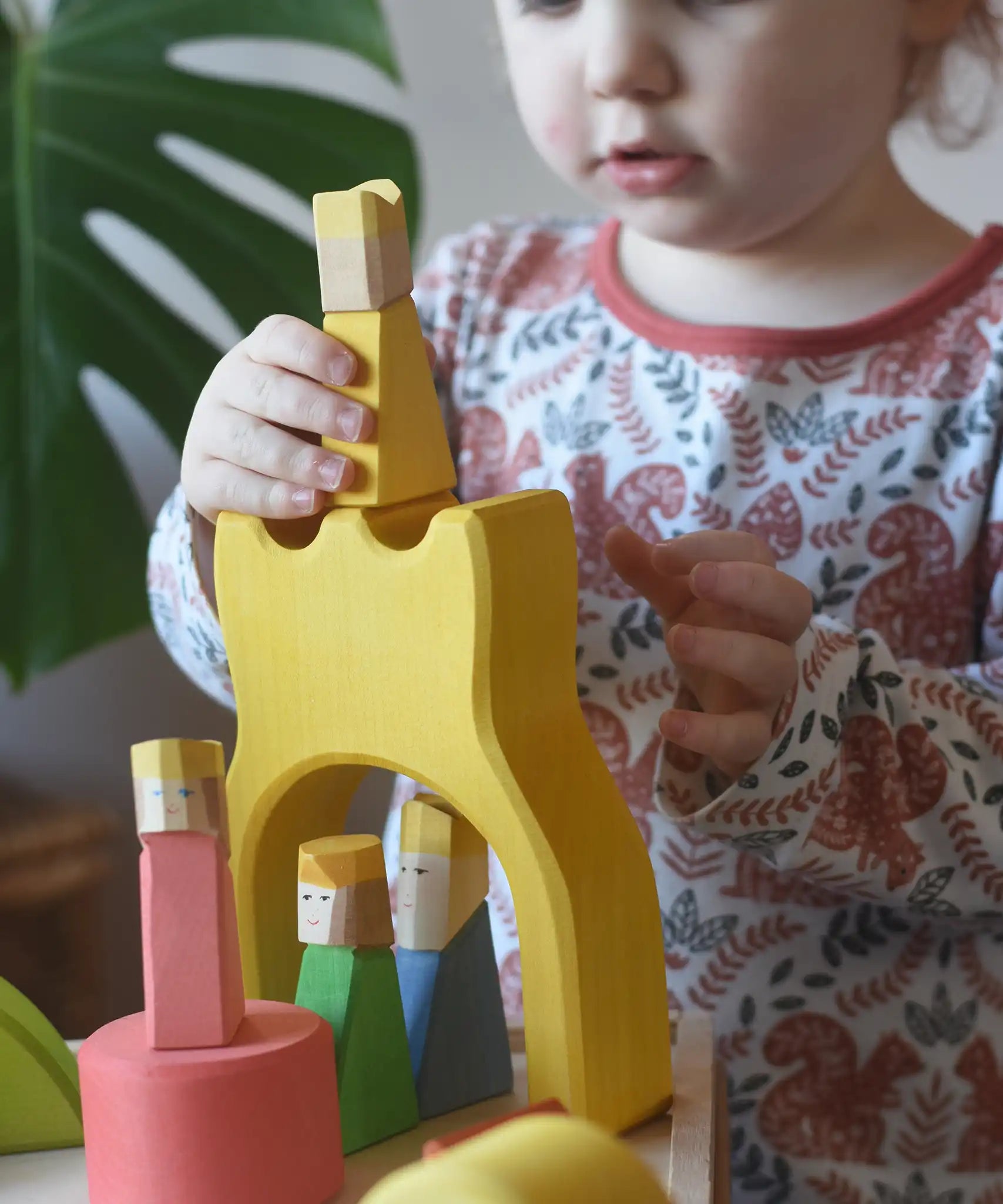 Yellow king wooden figure placed on the yellow castle piece from the Ostheimer Rainbow Castle Block set.