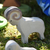 Ostheimer white ram wooden toy figure placed on grass in the Babipur garden. 