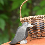 A raven bird figure placed on a pile of old books. 