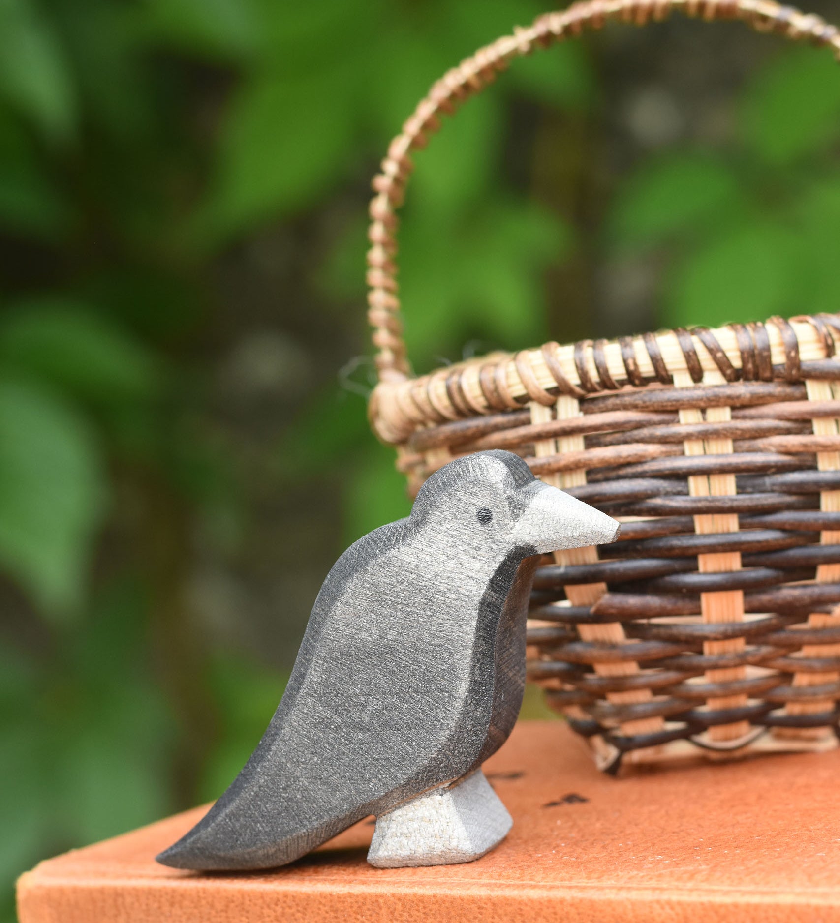 A raven bird figure placed on a pile of old books. 