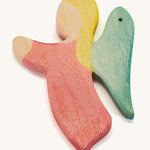A red wooden angel figure on a cream background