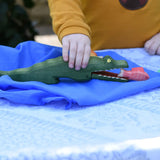 Ostheimer crocodile wooden toy figure played with by a child. Red fish has been placed in the crocodiles mouth. 