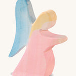 A red wooden Ostheimer kneeling angel figure on a cream background.