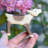 An Ostheimer reindeer calf wooden toy figure shown in an adult's hand for scale. Check out our full range of expertly crafted wooden toy figures and scenery here at Babipur.