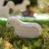 Ostheimer resting lamb wooden toy figure placed on grass in the Babipur garden.