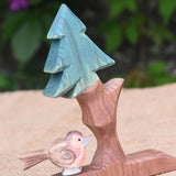 An Ostheimer robin figure placed on the base of the fir tree for dwarves.