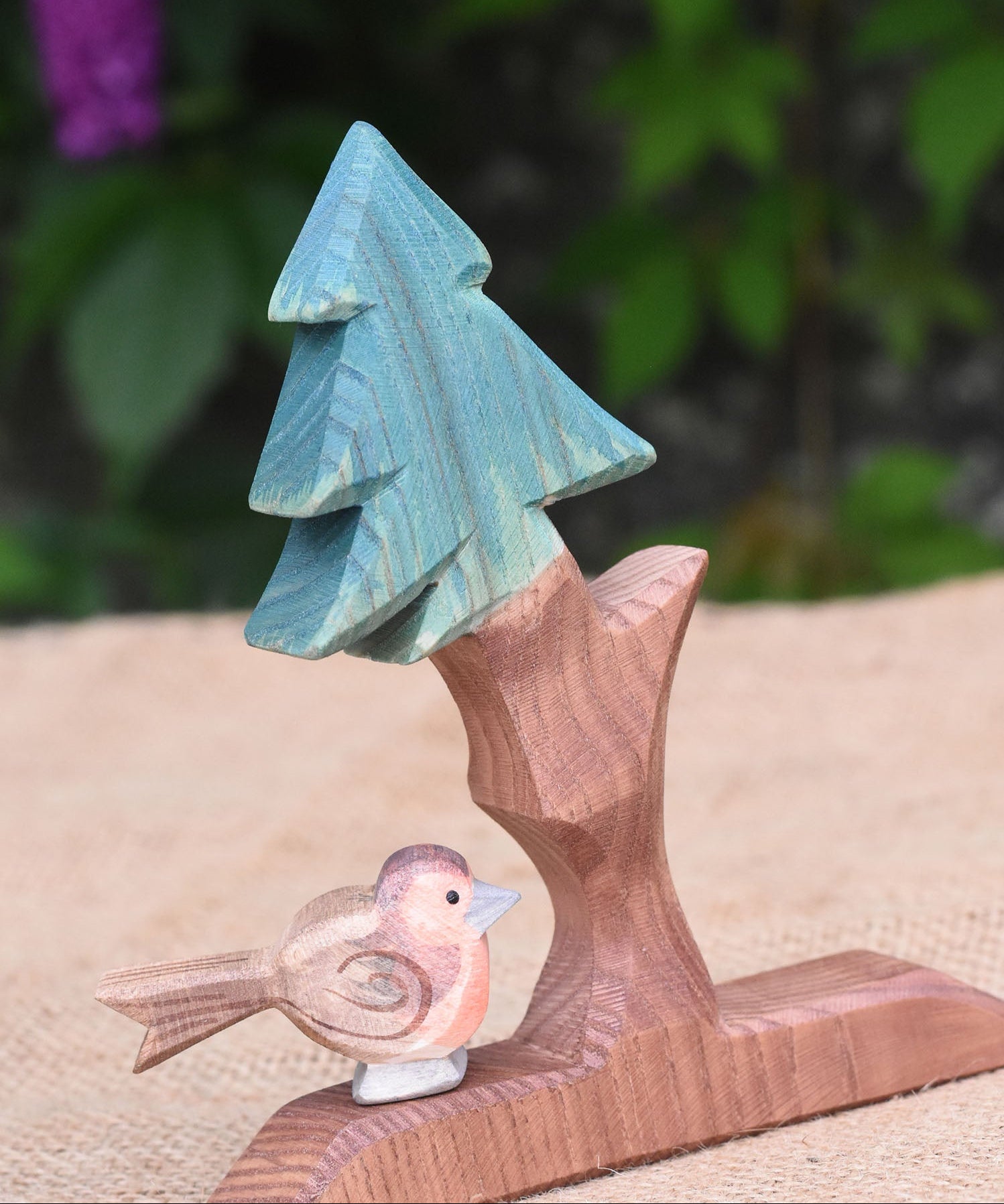 An Ostheimer robin figure placed on the base of the fir tree for dwarves.