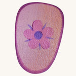 A pink wooden shield with a flower emblem on a cream background