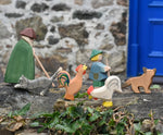 Ostheimer brown bremer and white rooster placed in a simple play scene on a stone wall outdoors. 
