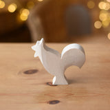 Ostheimer rooster paint your own wooden figure placed on a wooden surface. 