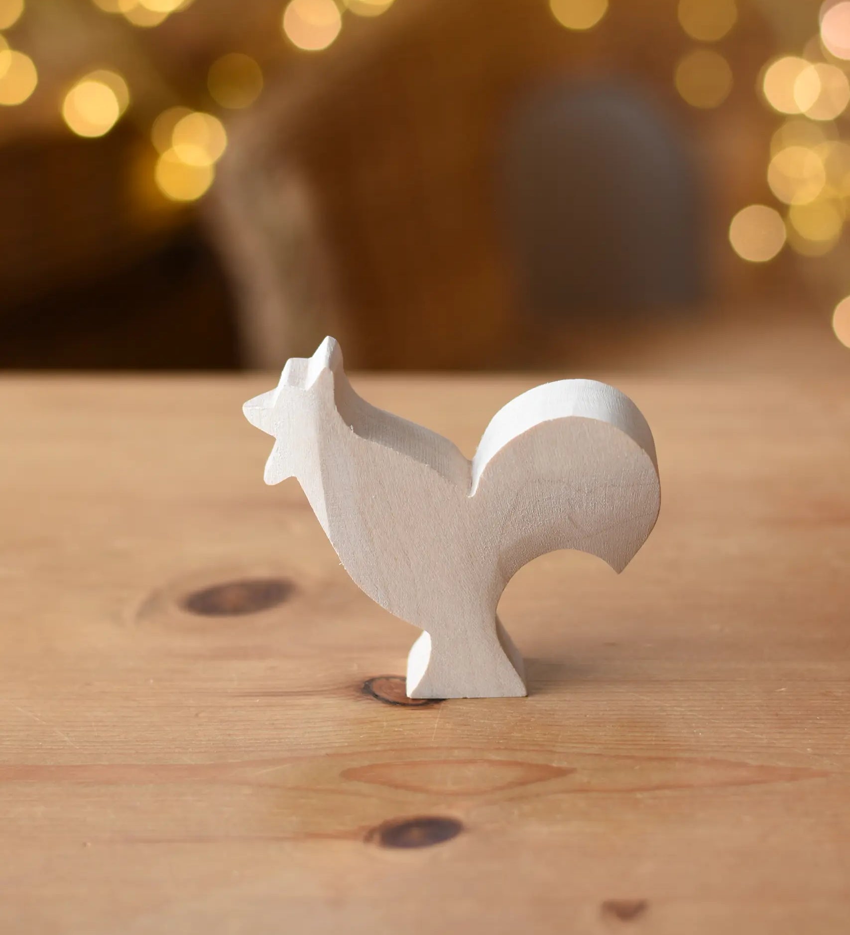 Ostheimer rooster paint your own wooden figure placed on a wooden surface. 