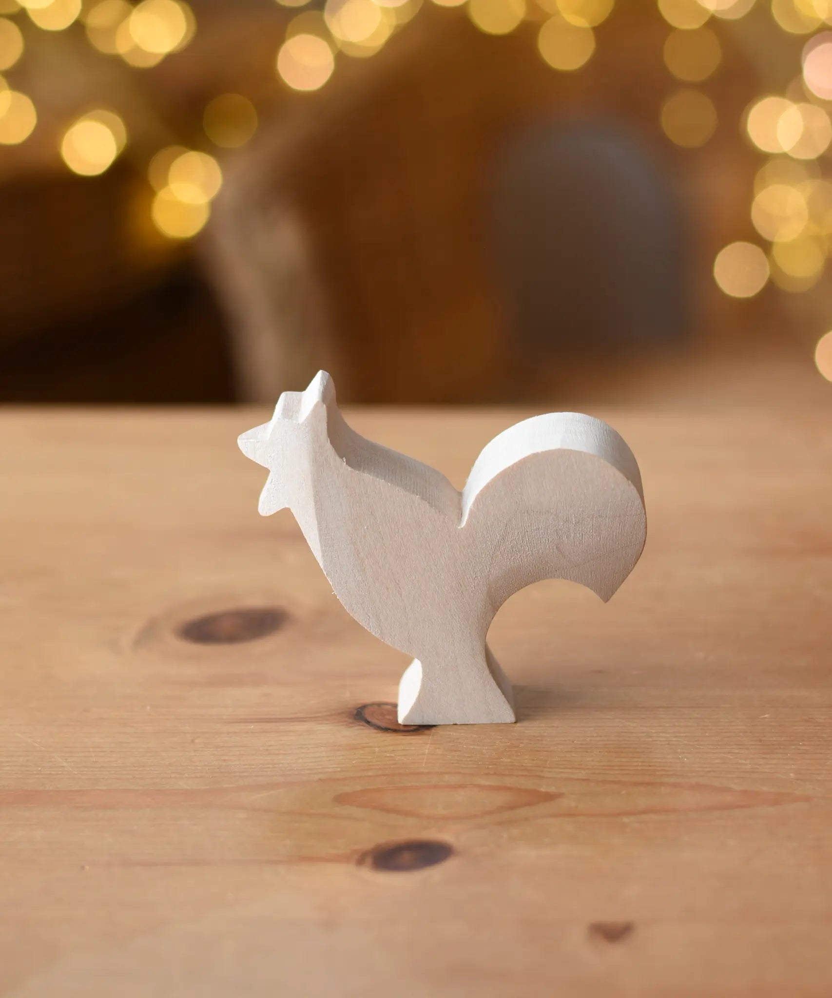 Ostheimer rooster paint your own wooden figure placed on a wooden surface. 