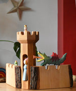 Ostheimer large wooden castle walls with a round tower in the middle. A dragon resting on one wall, frog king on the other and princesses in the tower.