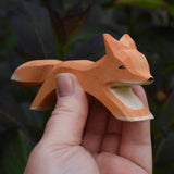 Ostheimer running fox wooden toy figure in an adult's hand.